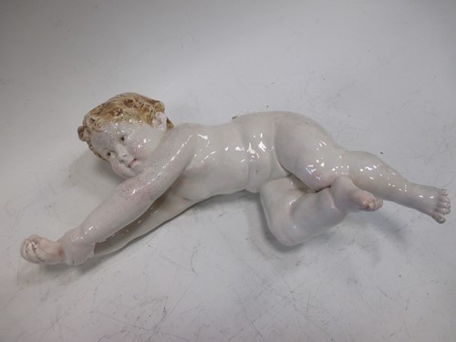 Lot 23 - A continental porcelain model of a cherub,...