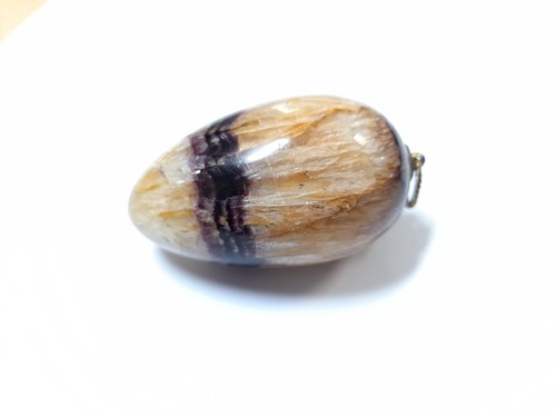 Lot 404 - An egg shaped pendant of Derbyshire blue john,...