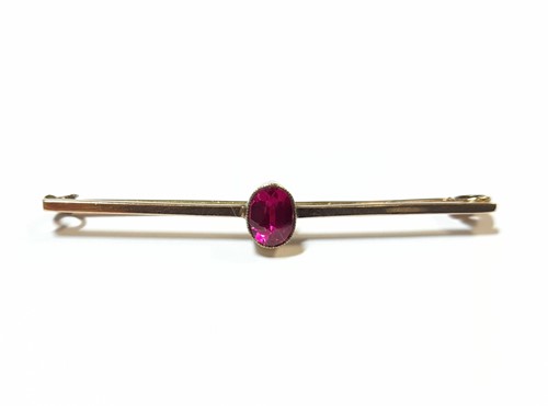 Lot 396 - Bar brooch with a synthetic ruby, tested as...