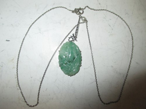 Lot 241 - A carved jadeite pendant and chain, cased