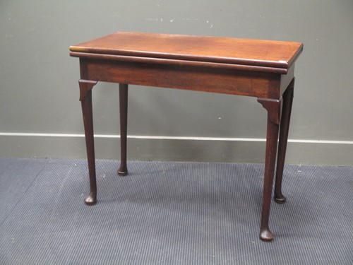 Lot 670 - A 19th century mahogany fold over card table...