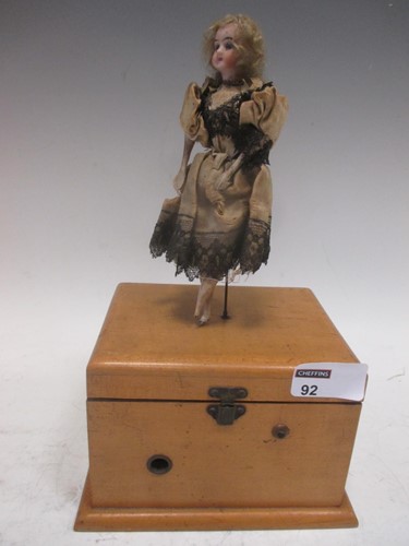 Lot 92 - An early 20th century musical box with doll...