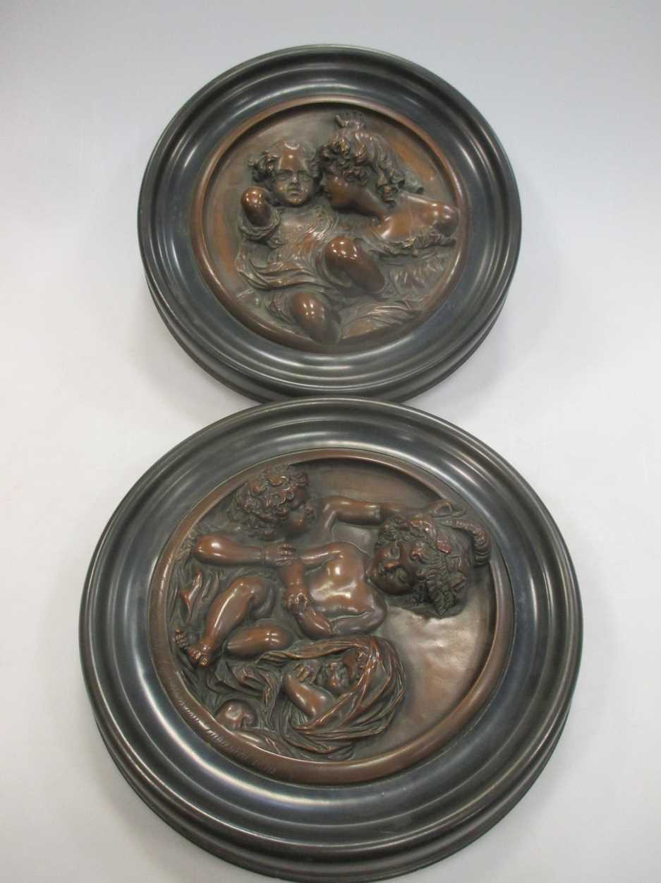 Lot 117 - A pair of pressed metal roundels of children,...