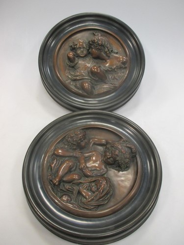 Lot 117 - A pair of pressed metal roundels of children,...