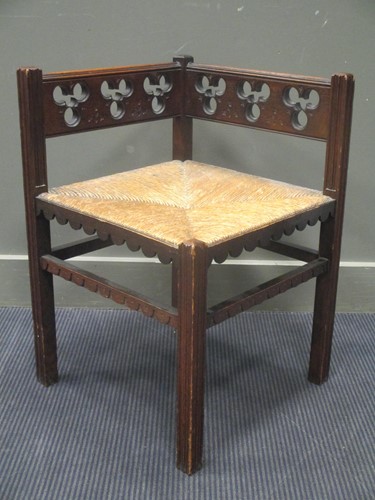 Lot 513 - A Gothic revival oak corner chair with rush seat