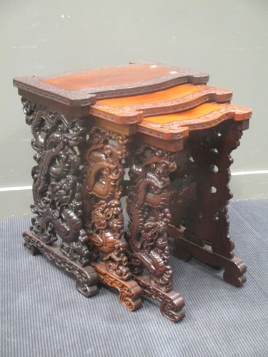 Lot 524 - A nest of three carved hardwood tables, 20th...