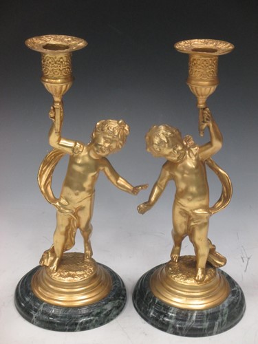 Lot 21 - A pair of gilt metal cherub candle sticks,...