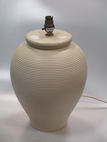 Lot 383 - A ribbed cream coloured ceramic lamp base of...