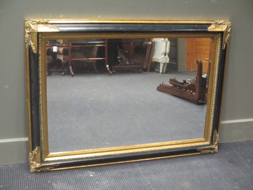 Lot 481 - A modern ebonised and gilt wall mirror 78 x...