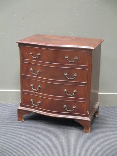 Lot 635 - A small reproduction serpentine front chest of...