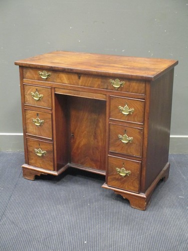 Lot 542 - A George III mahogany kneehole desk comprising...