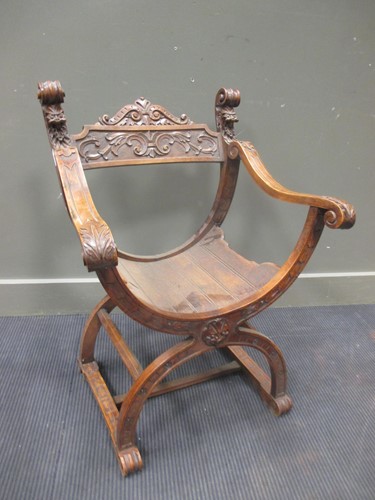 Lot 453 - A Tyrolean carved walnut X-frame armchair,...