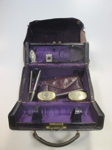 Lot 183 - A purple leather travelling cosmetic case by...