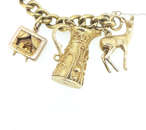 Lot 11 - A 9ct gold charm bracelet with many hallmarked charms