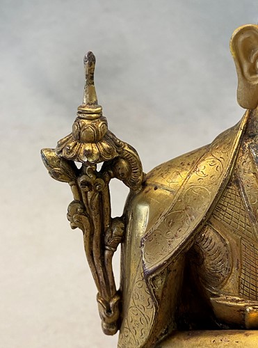 Lot 380 - A Tibetan or Mongolian gilt bronze lama