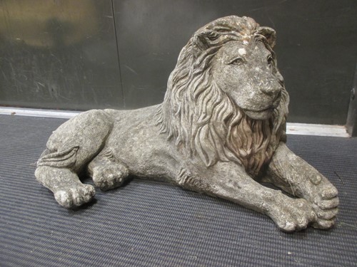 Lot 446 - A reconstituted stone recumbent lion, 34 x 63cm