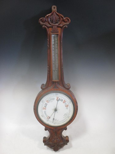 Lot 435 - A carved oak aneroid barometer, 82cm high
