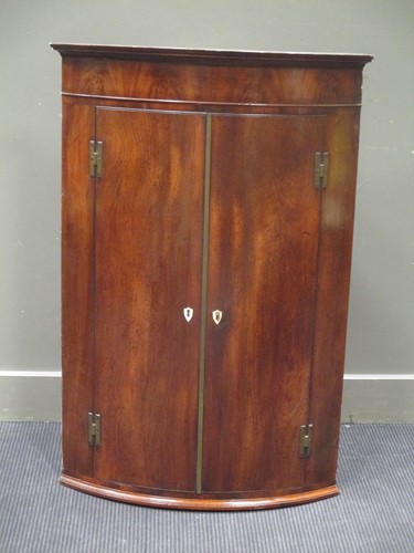 Lot 375 - A George III mahogany bow front hanging corner...