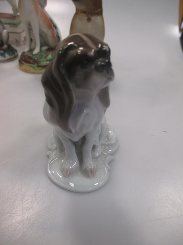 Lot 42 - A group of nine small ceramic model dogs,...