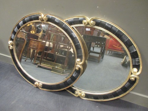 Lot 459 - A pair of Christopher Guy oval wall mirrors,...