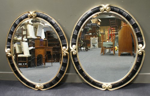 Lot 457 - A pair of Christopher Guy oval wall mirrors,...