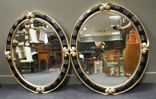 Lot 458 - A pair of Christopher Guy oval wall mirrors,...