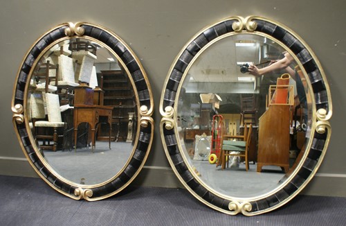Lot 456 - A pair of Christopher Guy oval wall mirrors,...