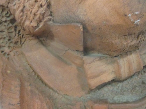 Lot 46 - A terracotta oval wall plaque sculpted with...