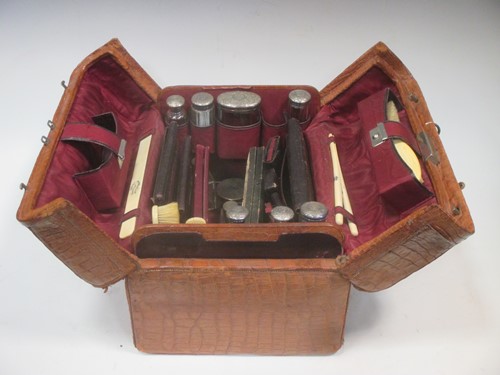 Lot 202 - A leather travelling bag with silver lidded...
