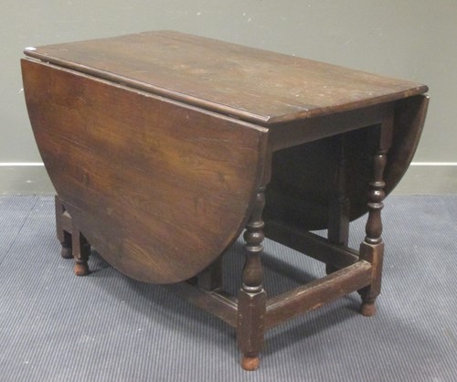 Lot 424 - A large oak gateleg table with oval top and...