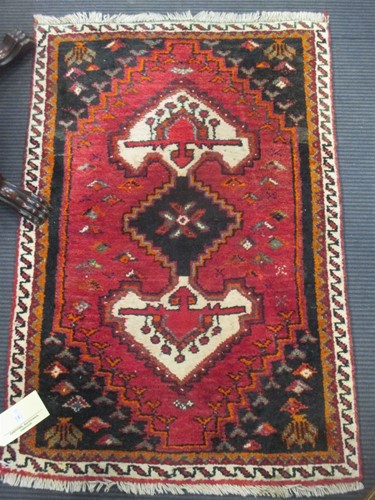 Lot 505 - A red ground rug with single medalion together...