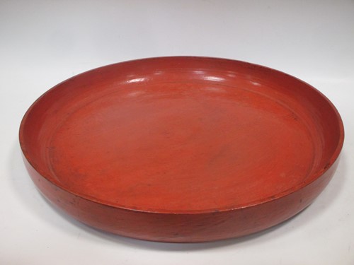 Lot 32 - A large red painted wooden platter, 53cm diameter