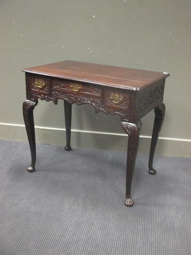 Lot 400 - An 18th century carved oak lowboy, the pinched...