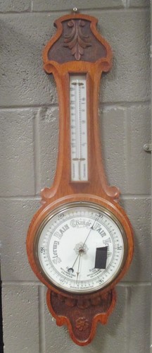 Lot 219 - An Edwardian carved oak aneroid barometer