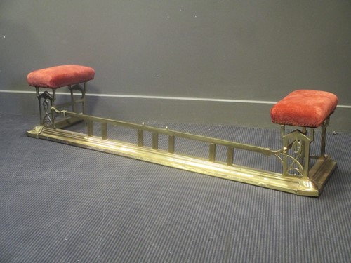Lot 599 - An Art Nouveau brass fender with upholstered side pieces