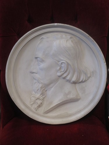 Lot 189 - A circular plaster relief plaque of a bearded...