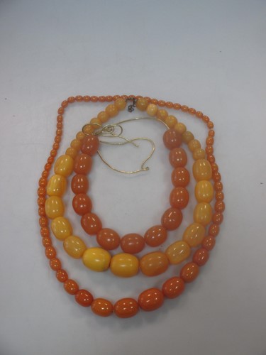Lot 392 - A graduated oval butterscotch coloured amber...