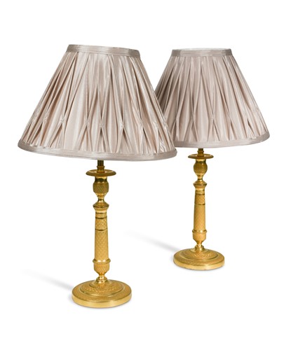 Lot 485 - A pair of Regency engine turned ormolu candlestick lamps, circa 1820