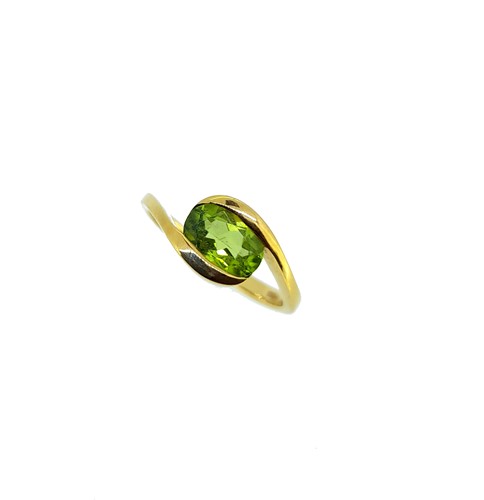 Lot 97 - An 18ct gold crossover style peridot ring