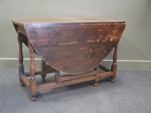 Lot 653 - An early 19th century oak gateleg dining table,...