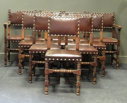 Lot 526 - A set of twelve leather upholstered oak dining...