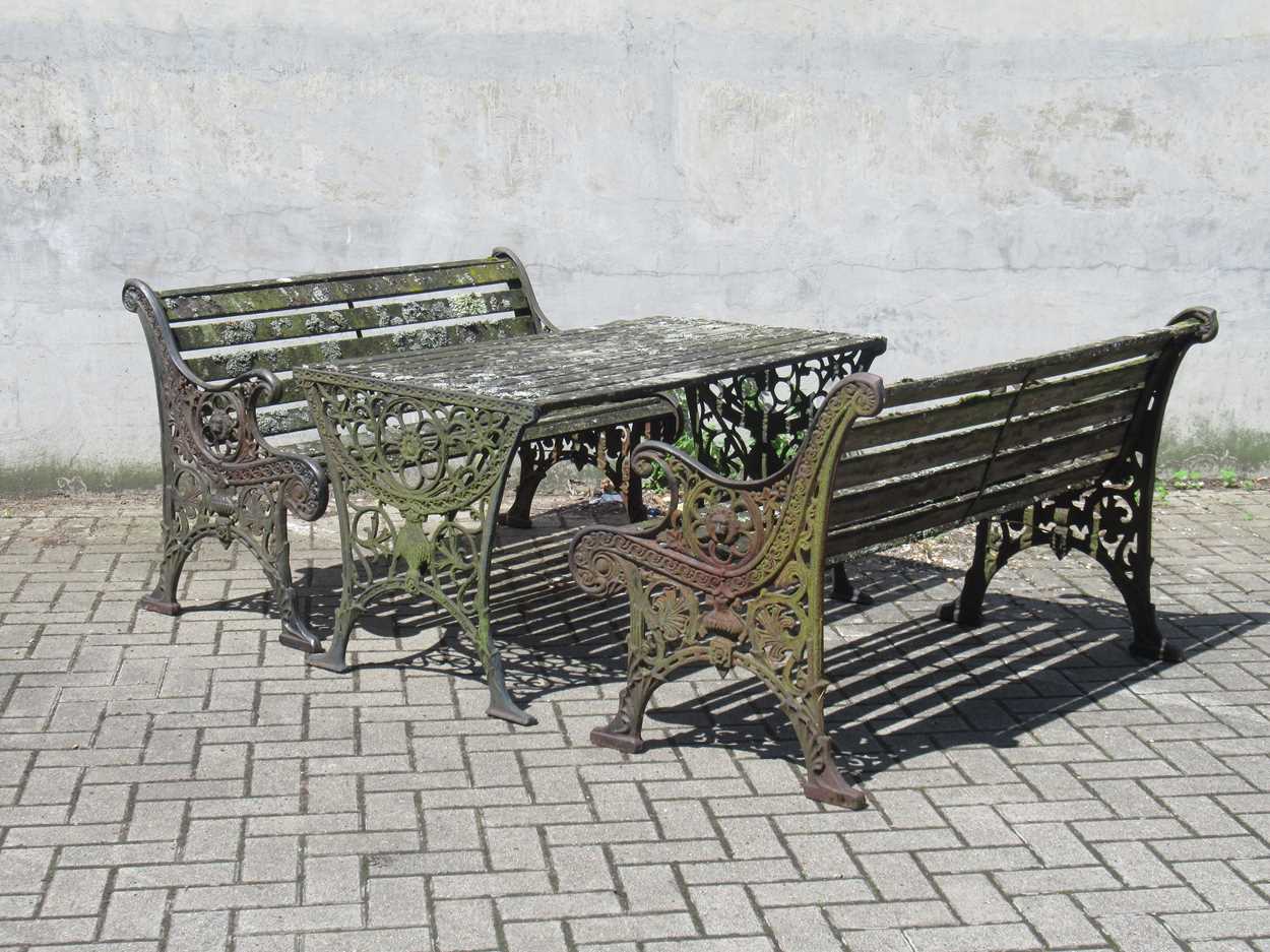 Lot 576 - Two cast iron frame garden benches and a table....