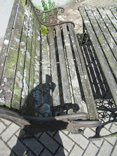 Lot 576 - Two cast iron frame garden benches and a table....
