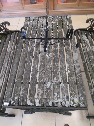 Lot 576 - Two cast iron frame garden benches and a table....