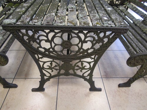 Lot 576 - Two cast iron frame garden benches and a table....