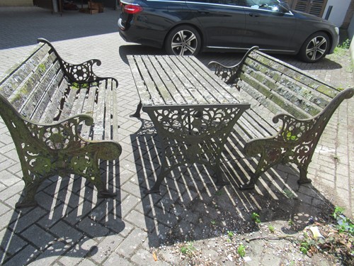 Lot 576 - Two cast iron frame garden benches and a table....
