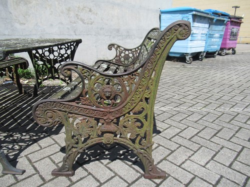 Lot 576 - Two cast iron frame garden benches and a table....