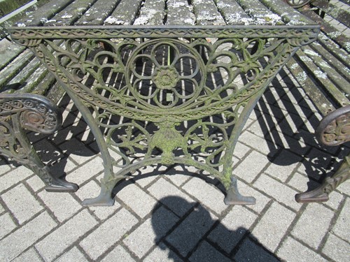 Lot 576 - Two cast iron frame garden benches and a table....