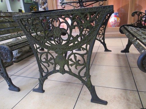 Lot 576 - Two cast iron frame garden benches and a table....