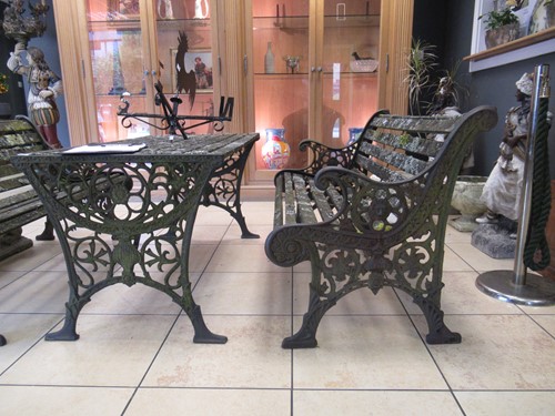 Lot 576 - Two cast iron frame garden benches and a table....